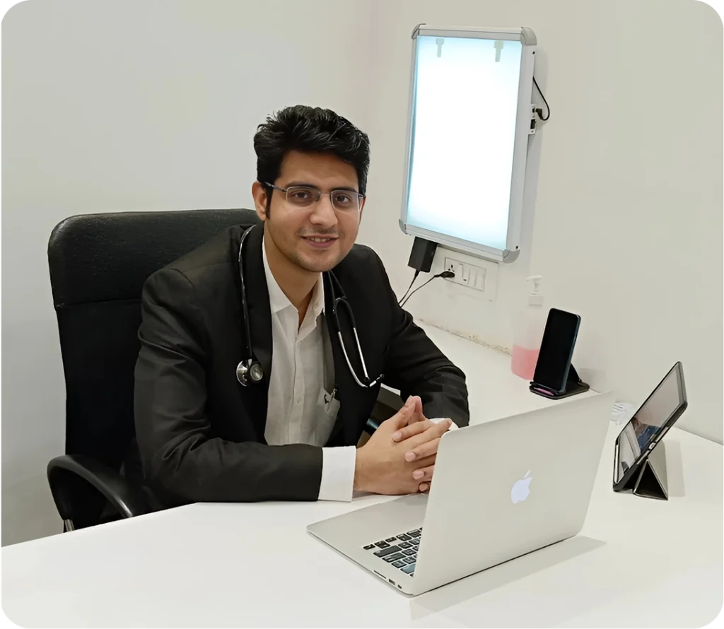 Dr. Sameer Lote sitting at his office desk with a laptop, looking professional